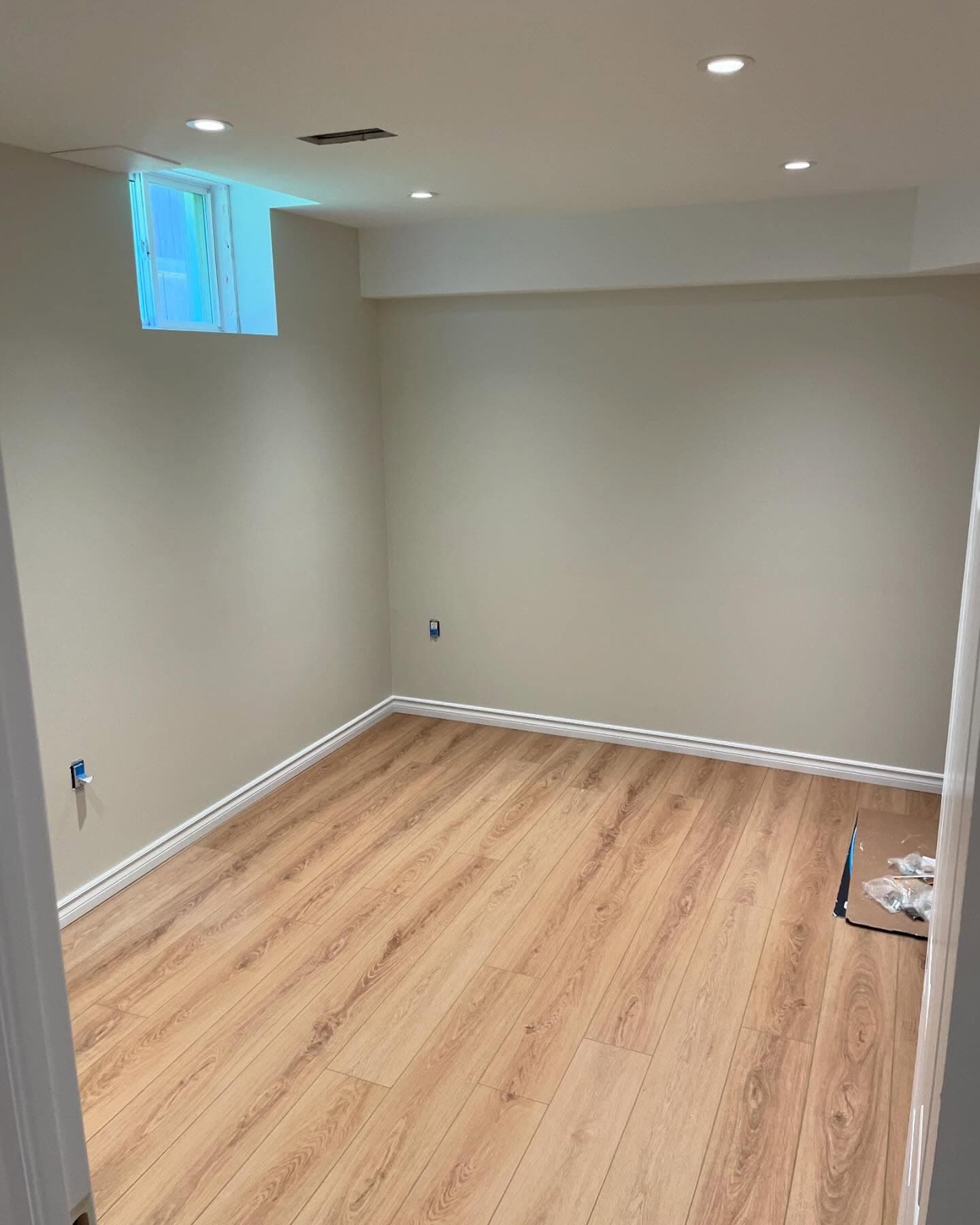 Finished lower-level bedroom with laminate flooring